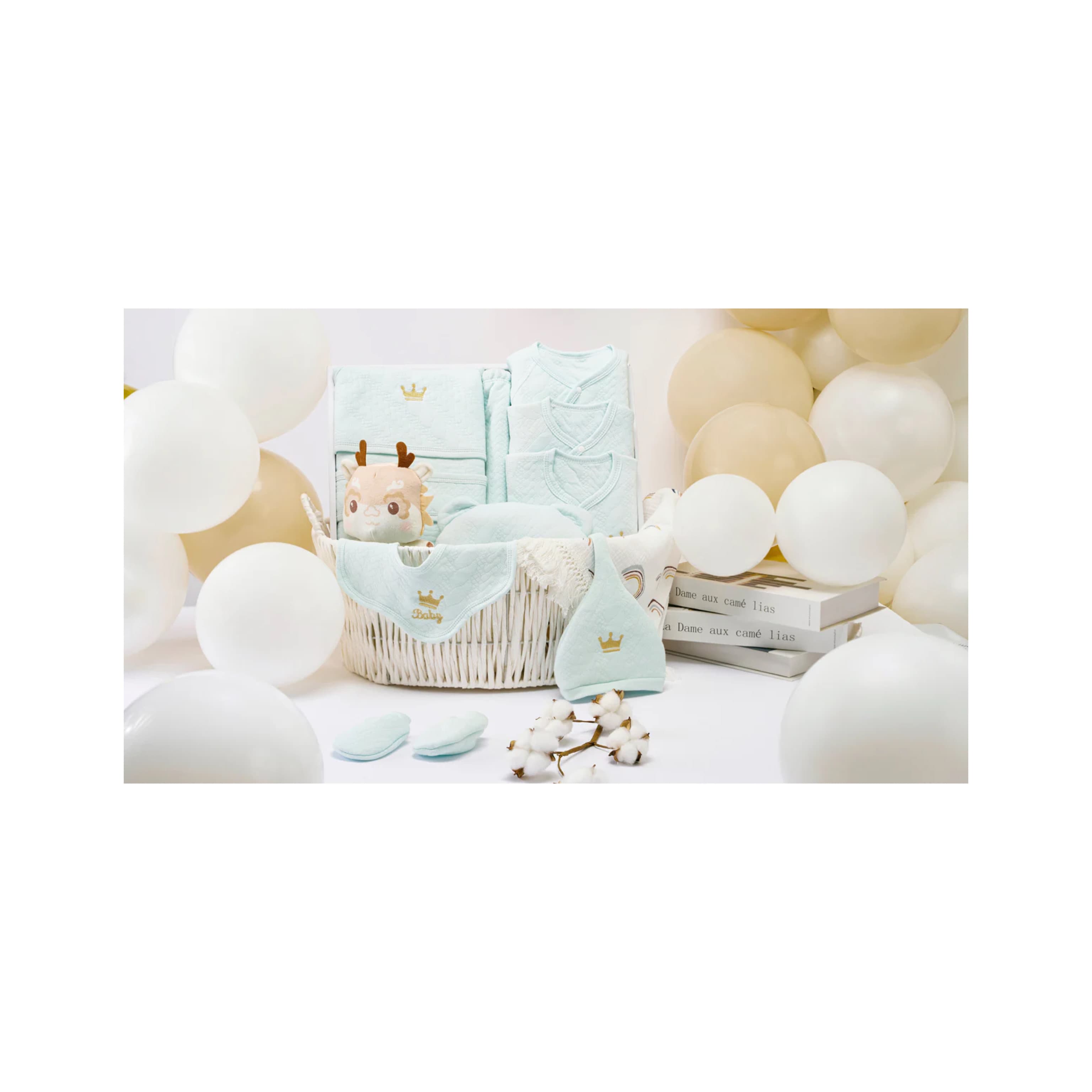 Luxury baby boy gift hamper featuring soft essentials like bibs and towels, beautifully arranged in a basket surrounded by neutral balloons—perfect for baby showers or first birthdays.
