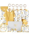 Close-up of leafy newborn bodysuit and accessories in soft organic-style fabric