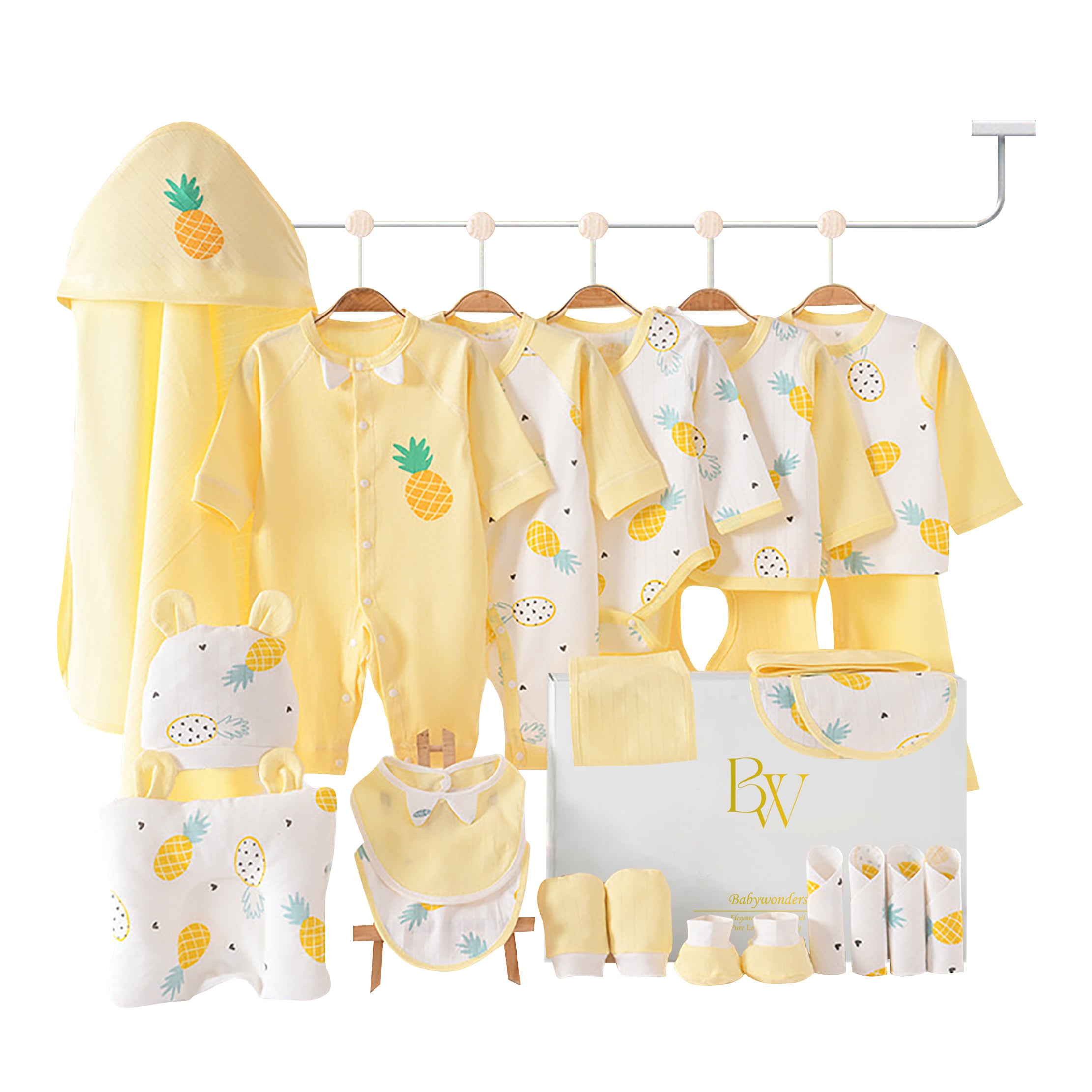 Pineapple-themed baby gift set with bodysuit, bibs, towel, wrap, socks, gloves, and pillow in a tropical-inspired gift box