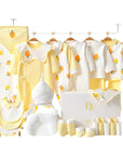 Nature-themed baby gift set featuring yellow tree print bodysuit, mittens, and socks in neutral tones