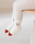 Baby wearing cute bow-design cotton socks with red toe detail