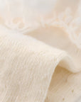 Close-up of soft cotton knit fabric from baby lace socks, showing fine breathable texture