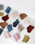 Baby and toddler ribbed socks in assorted neutral and pastel colors displayed flat on white background