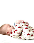 Baby wearing cream cotton romper with red heart design, soft and cozy outfit ideal for lounging or sleeping.