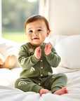 Smiling baby wearing army green cotton knitted romper with sun and rainbow pattern, soft and warm infant jumpsuit.
