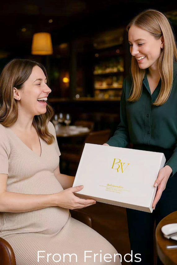 Pregnant woman receiving Babywonders gift box from friend at a restaurant