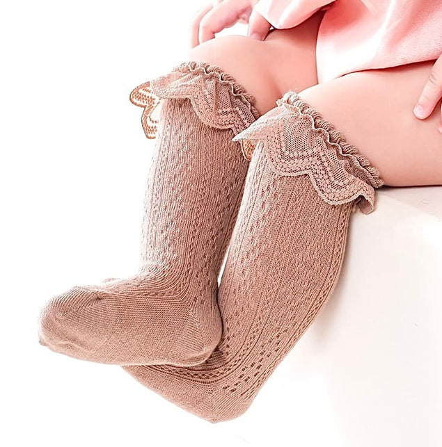 Infant wearing brown lace knit baby socks with scalloped ruffle edge – stylish and cozy fit.