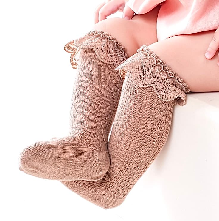 Infant wearing brown lace knit baby socks with scalloped ruffle edge – stylish and cozy fit.