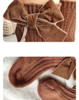 Close-up of brown velvet bow baby socks — premium ribbed cotton and soft bow texture.