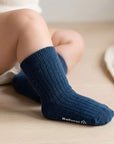 Baby wearing navy cotton socks on feet, soft breathable fabric