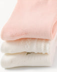 Folded stack of soft pink and white cotton baby socks