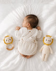 Newborn baby resting beside a handcrafted crochet twin lion rattle set with lion comfort toy and wooden ring rattle, a thoughtful baby shower gift and nursery essential.