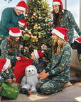 Family wearing green Christmas pajamas with festive animal print, matching holiday sleepwear set