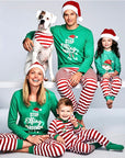 Family wearing matching Christmas pajamas with green tops and red white striped pants, holiday loungewear set