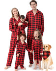 Happy family wearing red and black plaid matching pajamas with children and dog