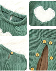 Close-up of heart embroidery and button details on dark green knitted baby romper