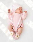 Baby wearing knitted flower anti-slip baby socks with soft cotton grip booties in cosy pastel nursery setting