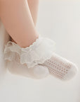 Baby feet wearing elegant lace cotton socks for newborns and toddlers