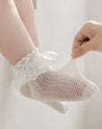 Baby wearing delicate lace frill cotton socks with bow detail