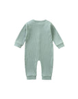 Back view of light green ribbed cotton baby romper showing fine knit texture and cuffed sleeves.