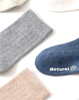 Flat lay of multi-color cotton socks for kids in blue, gray, beige, and pink — soft breathable material.