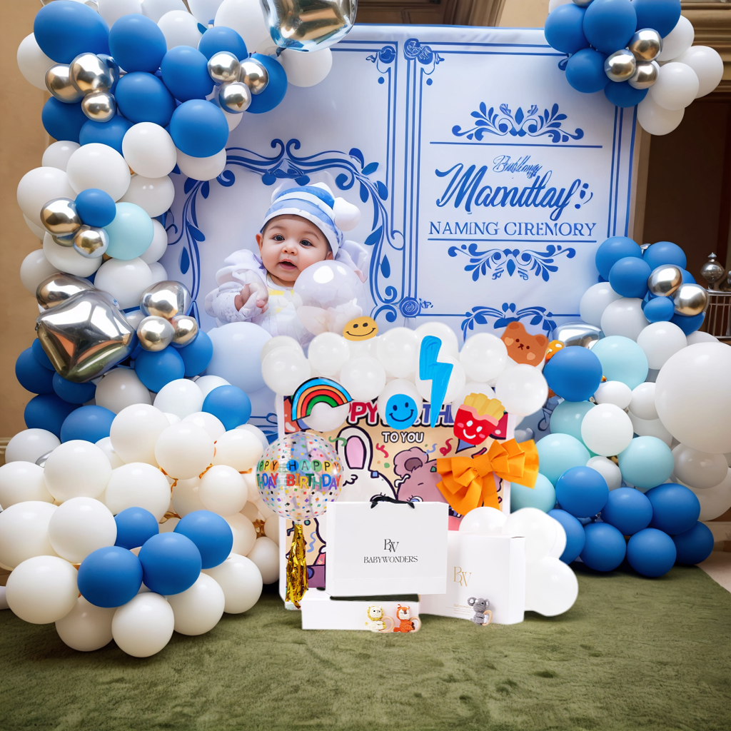 Baby in a blue and white hat surrounded by balloons and a decorative sign  featuring Newborn Gifts from Baby Wonders UK for a naming ceremony.