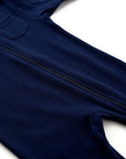 Close-up of navy blue cotton baby romper showing front zipper and soft fabric texture.