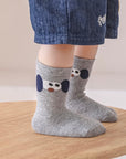 Baby wearing grey cotton socks with cute embroidered pattern – baby socks UK