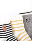 Close-up of striped cotton baby socks in grey and cream tones