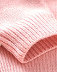 Ribbed sleeve cuff detail of pink knitted baby romper