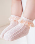 Baby wearing soft pink lace frill socks made of breathable cotton, perfect for everyday comfort.