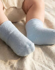 Baby wearing light blue cotton crew socks on feet, soft and breathable fabric