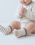 baby wearing retro striped winter cotton socks in neutral beige and brown tones for toddlers and newborns