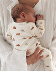 Newborn baby wearing a soft ribbed baby sleepsuit in minimalist neutral style for cosy everyday comfort