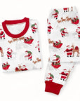 Flat lay of matching Christmas pajamas set with Santa Claus and reindeer print, red cuffs.