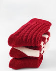 Stack of thick red baby socks showcasing cozy thermal material and premium winter warmth for infants.