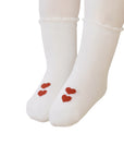 Close-up of baby wearing white cotton socks with red heart pattern