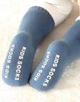 Close-up of toddler blue socks with non-slip lettering for safe indoor wear