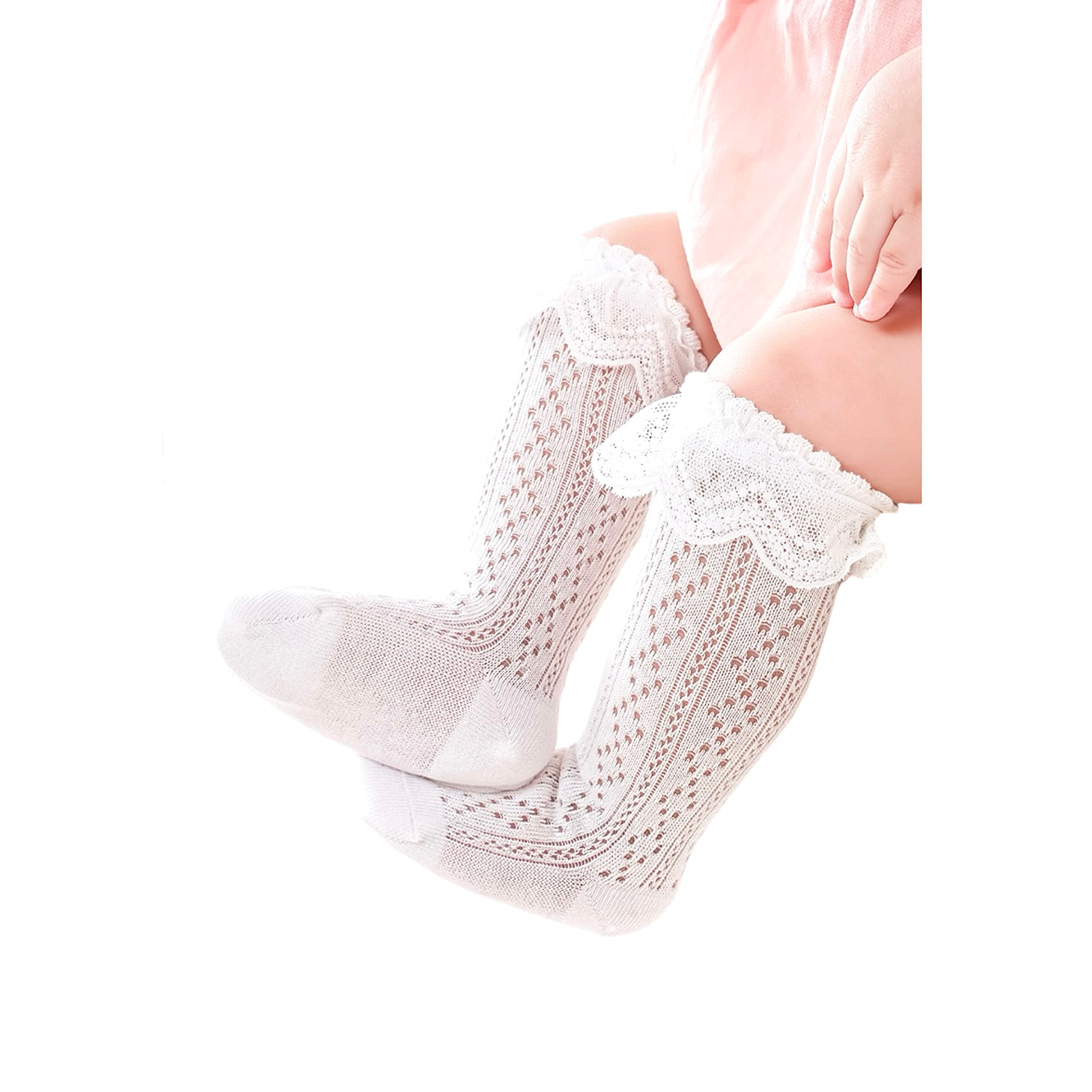 Baby girl wearing white lace knit socks with ruffle trim – breathable cotton knee-high design.