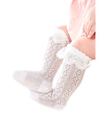 Baby girl wearing white lace knit socks with ruffle trim – breathable cotton knee-high design.