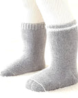 Child wearing thick grey cotton socks for winter warmth and comfort