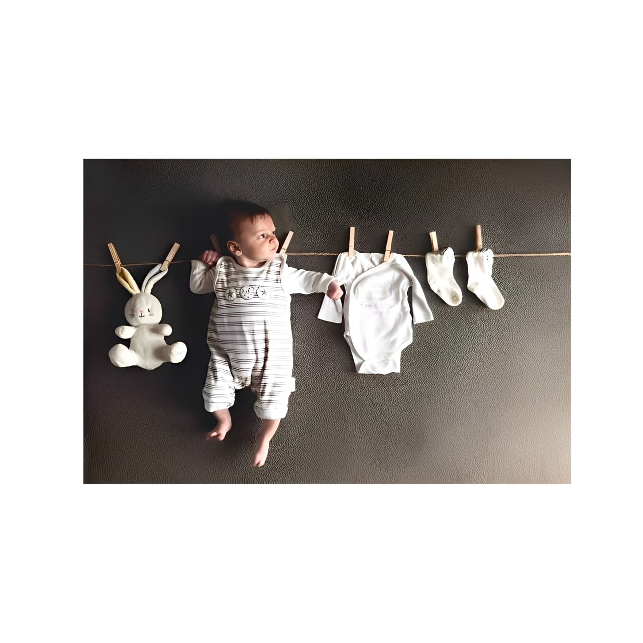Personalized baby gift idea with newborn and clothes on clothesline, creative keepsake for first-time parents.