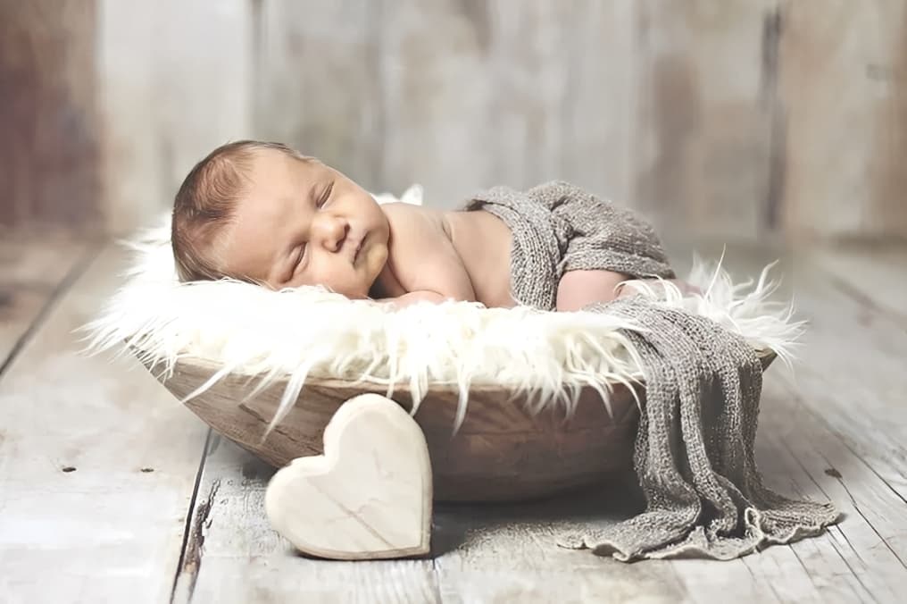 Newborn baby sleeping in cozy basket, thoughtful childbirth gift inspiration