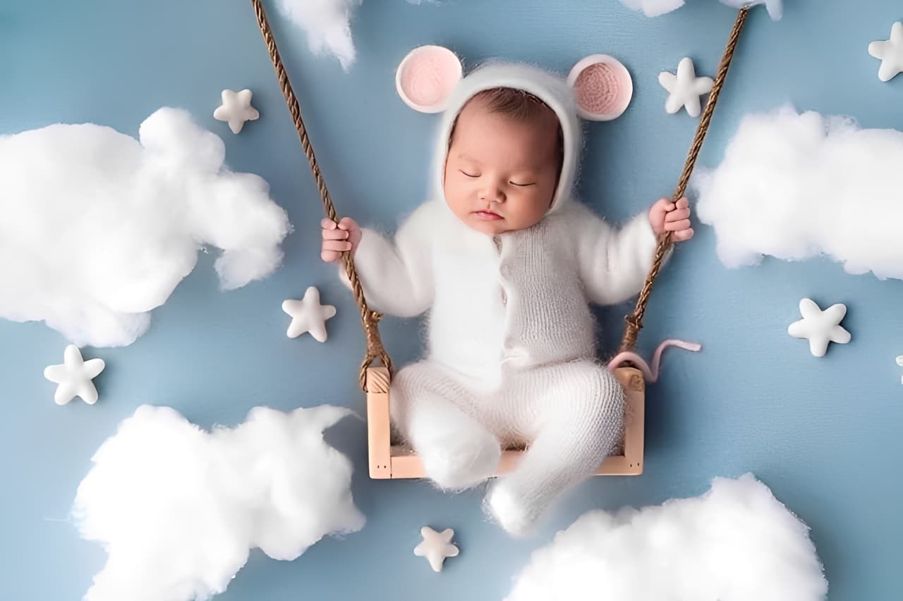 Cute newborn baby in white onesie lying on clouds and sky background, perfect infant gift set idea for new parents.