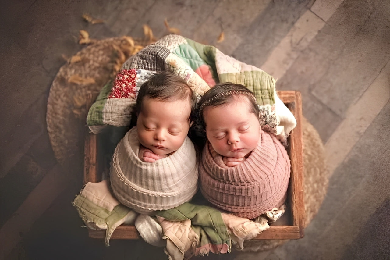 Two newborn babies wrapped in organic cotton swaddles, eco-friendly newborn gift set inspiration