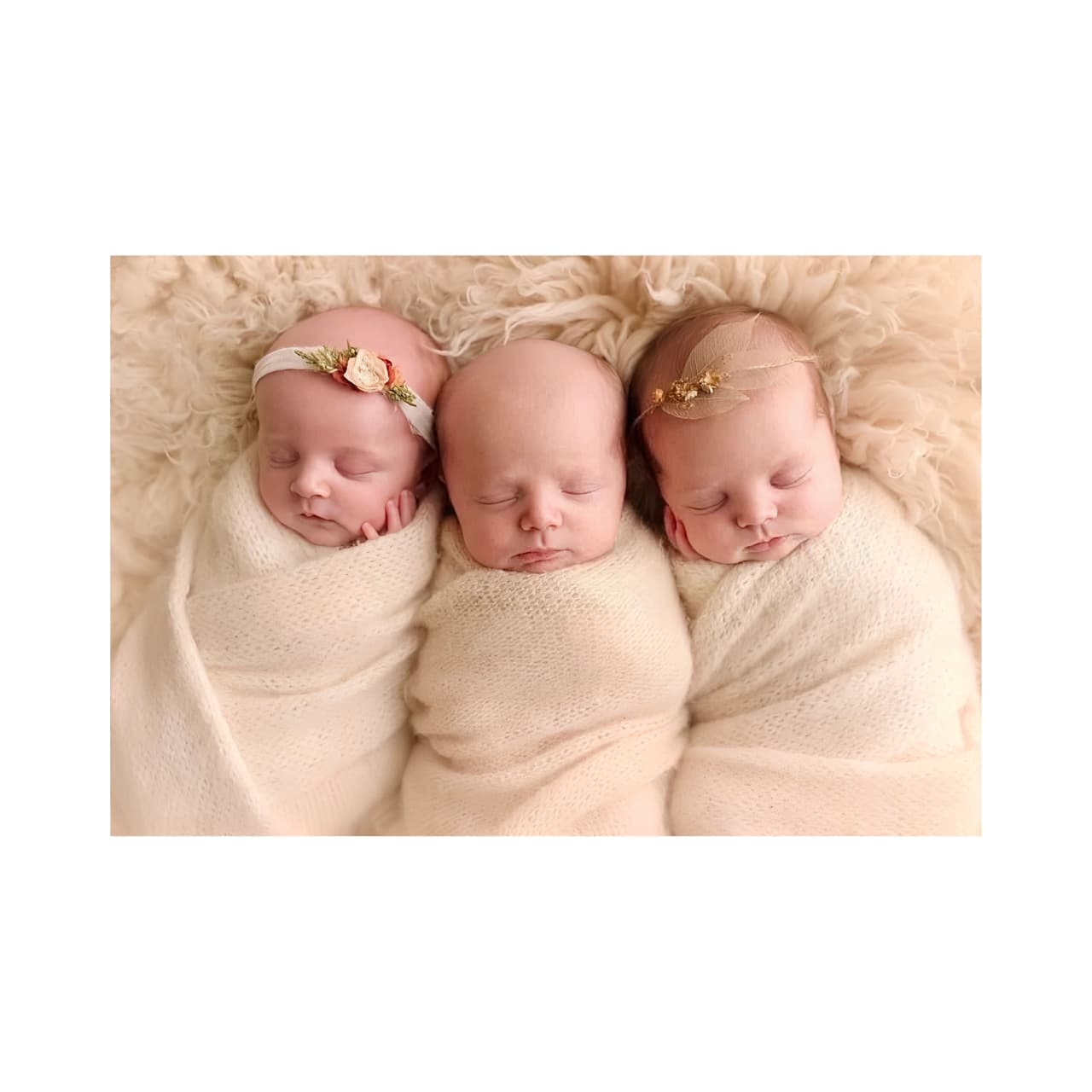 A luxurious portrait of three swaddled newborns in coordinated cream wraps and soft headbands, symbolizing elegance and tenderness—perfect for luxury baby gift inspiration.