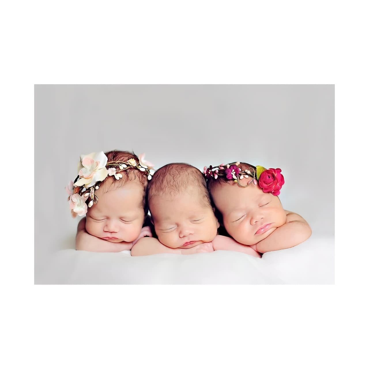 Adorable trio of newborn babies with floral headbands, symbolising love and connection in long-distance baby gifting—perfect for BabyWondersUK gift set campaigns.