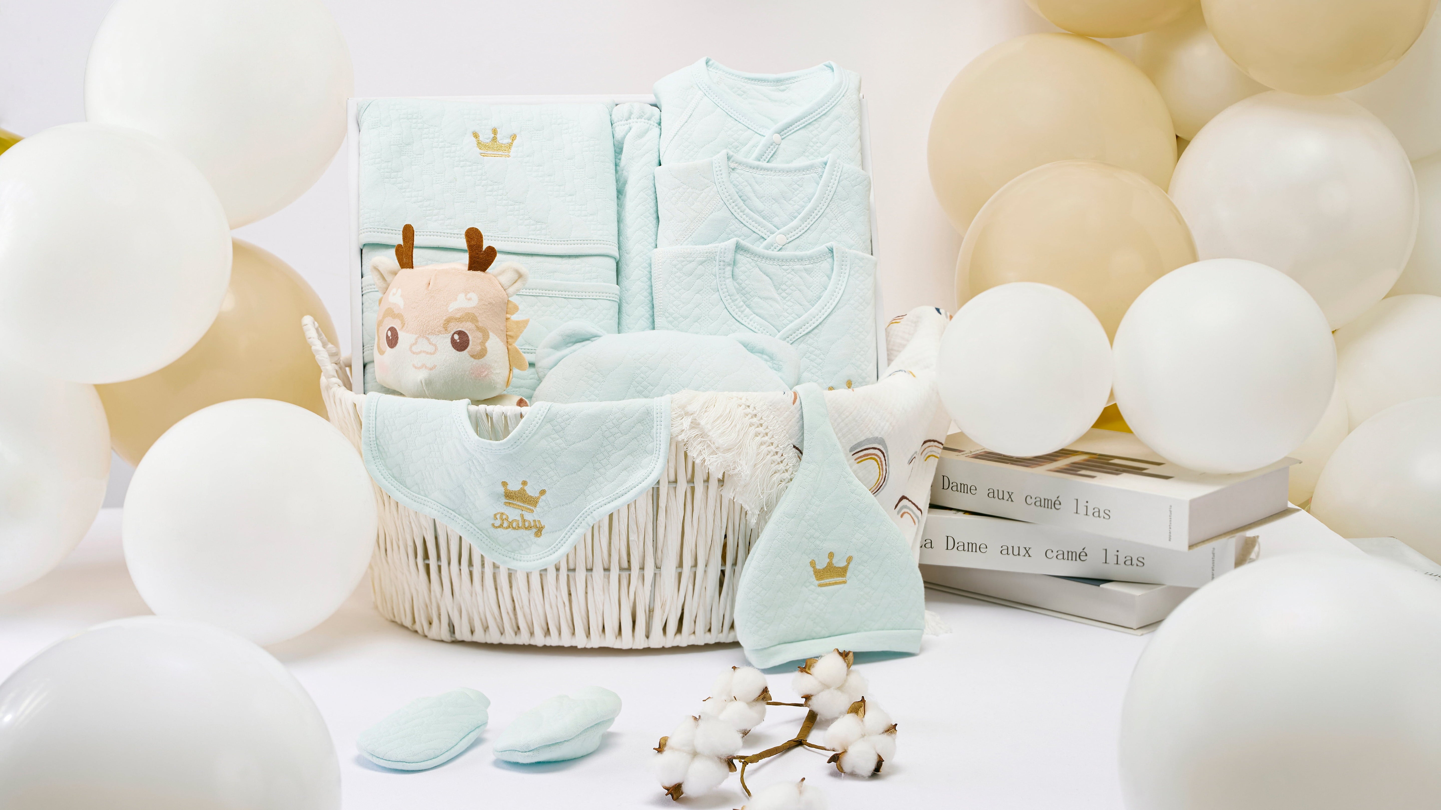 Luxury baby boy gift hamper featuring soft essentials like bibs and towels, beautifully arranged in a basket surrounded by neutral balloons—perfect for baby showers or first birthdays.