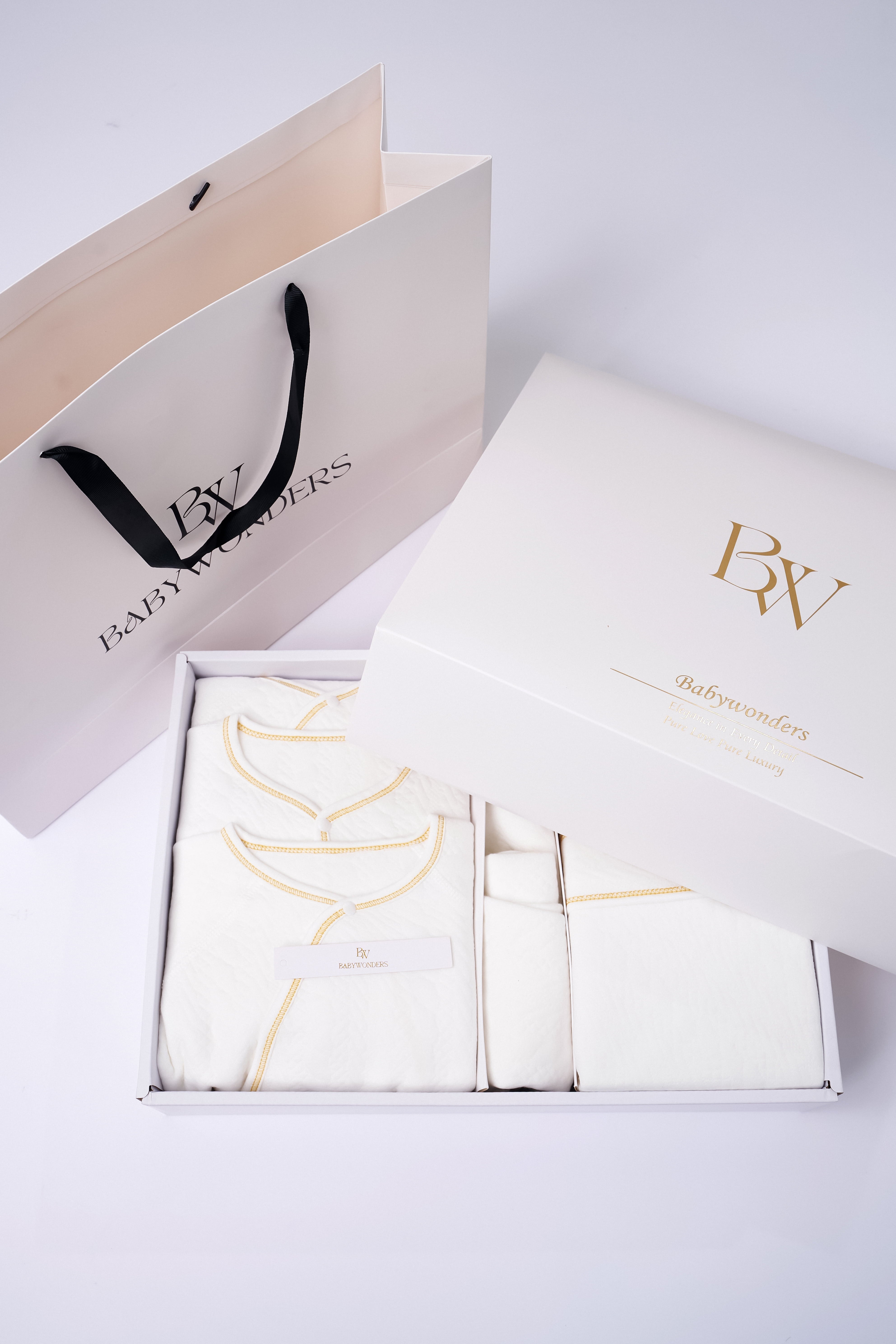 Thoughtfully curated newborn gift box including soft white baby garments, presented in a premium BabyWondersUK gift box and bag—perfect for parents who already have the basics.
