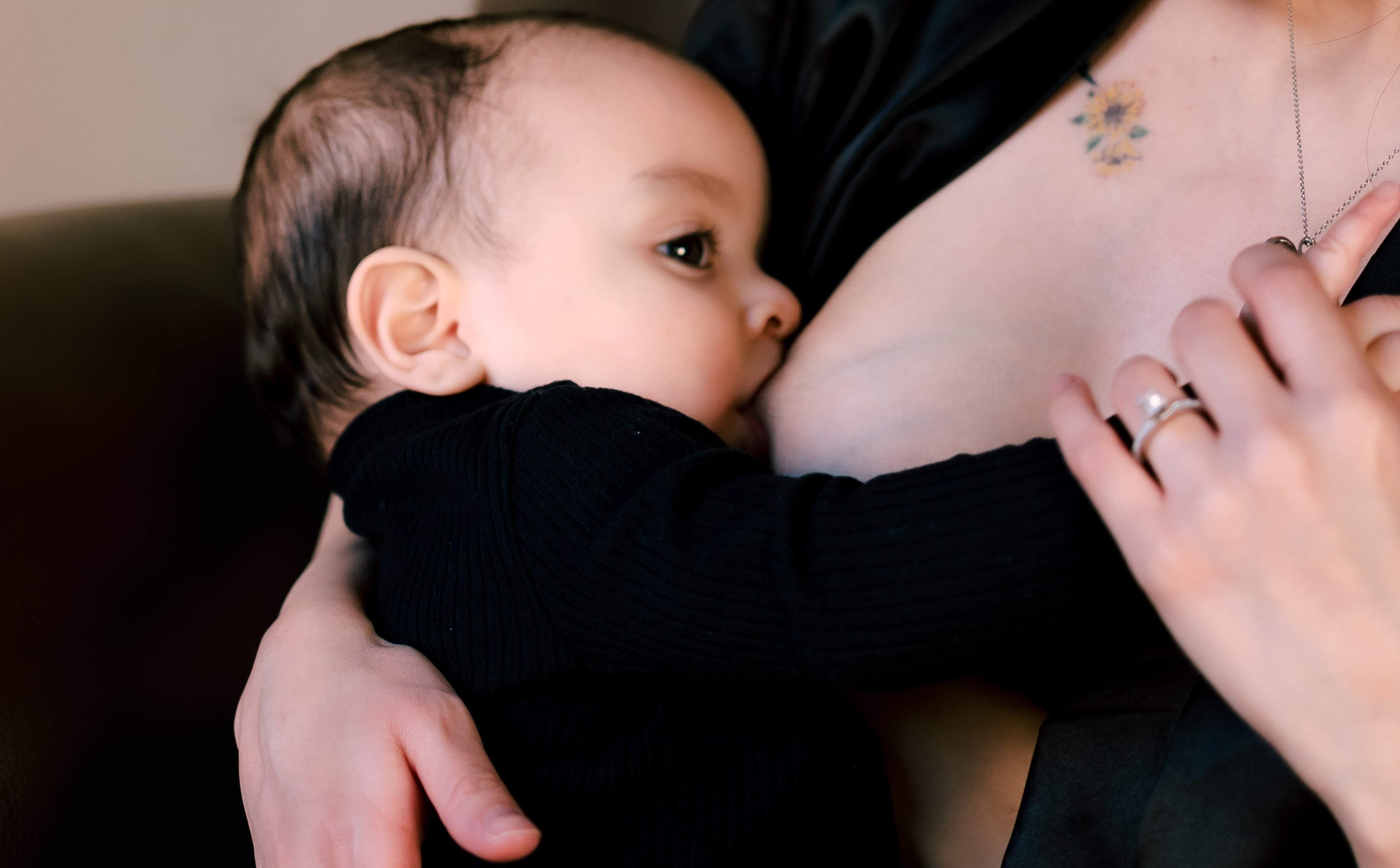 Mother breastfeeding her baby, highlighting the intimate bond and practical challenges of nursing—topics explored in the context of using electronic breast pumps for support